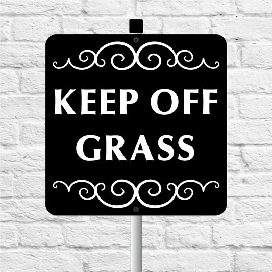 Black sign with 'KEEP OFF GRASS' text on a white brick wall background
