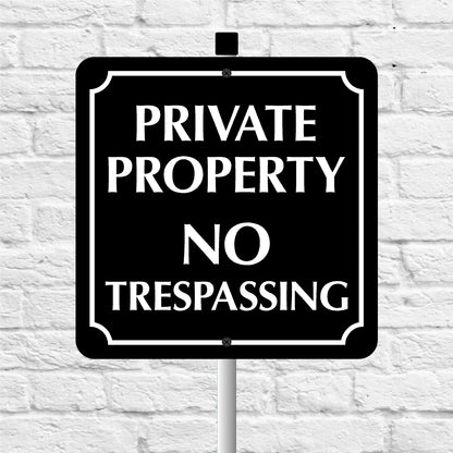 Black and white 'Private Property No Trespassing' sign on a white brick wall background