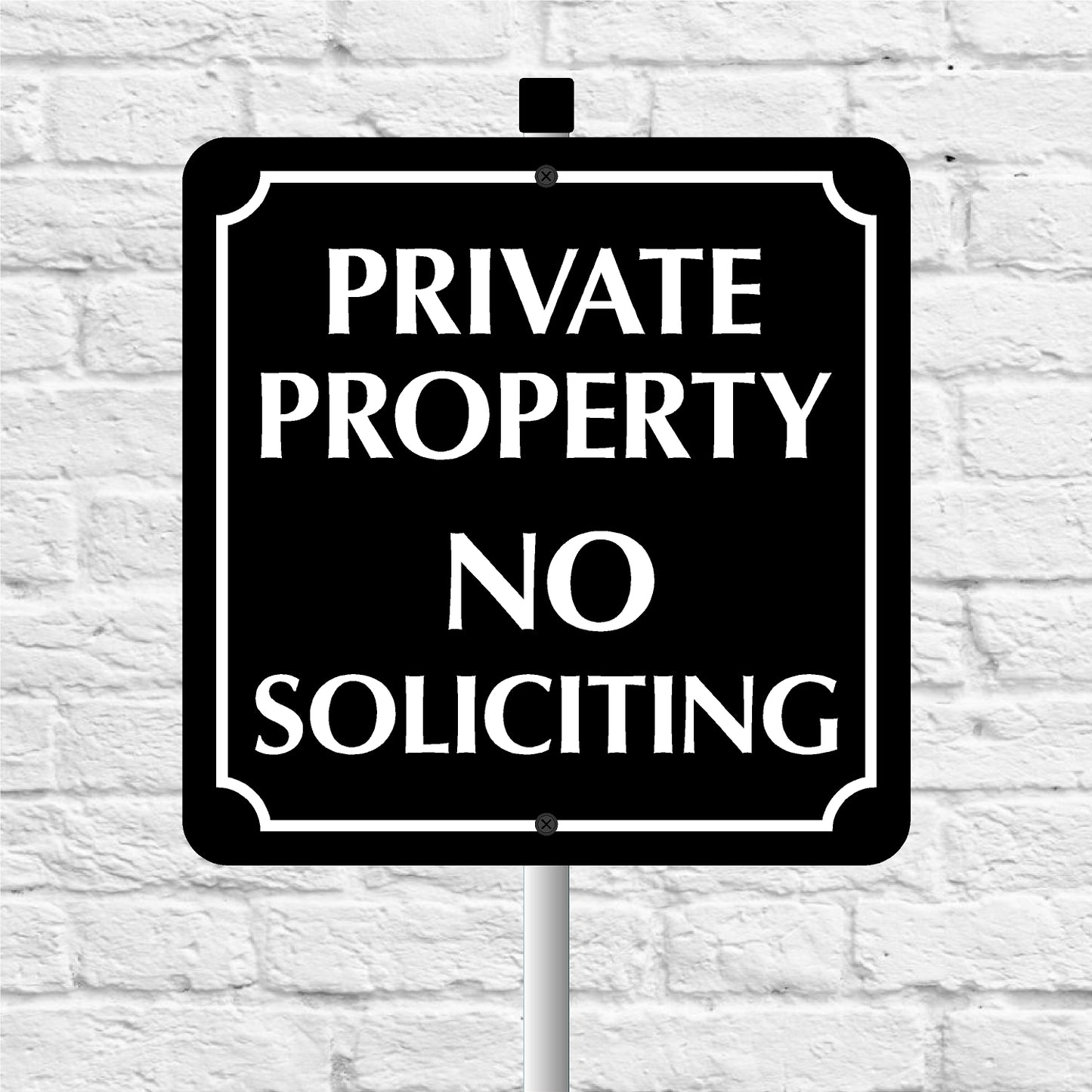 Black and white 'Private Property No Soliciting' sign against a light gray brick wall.