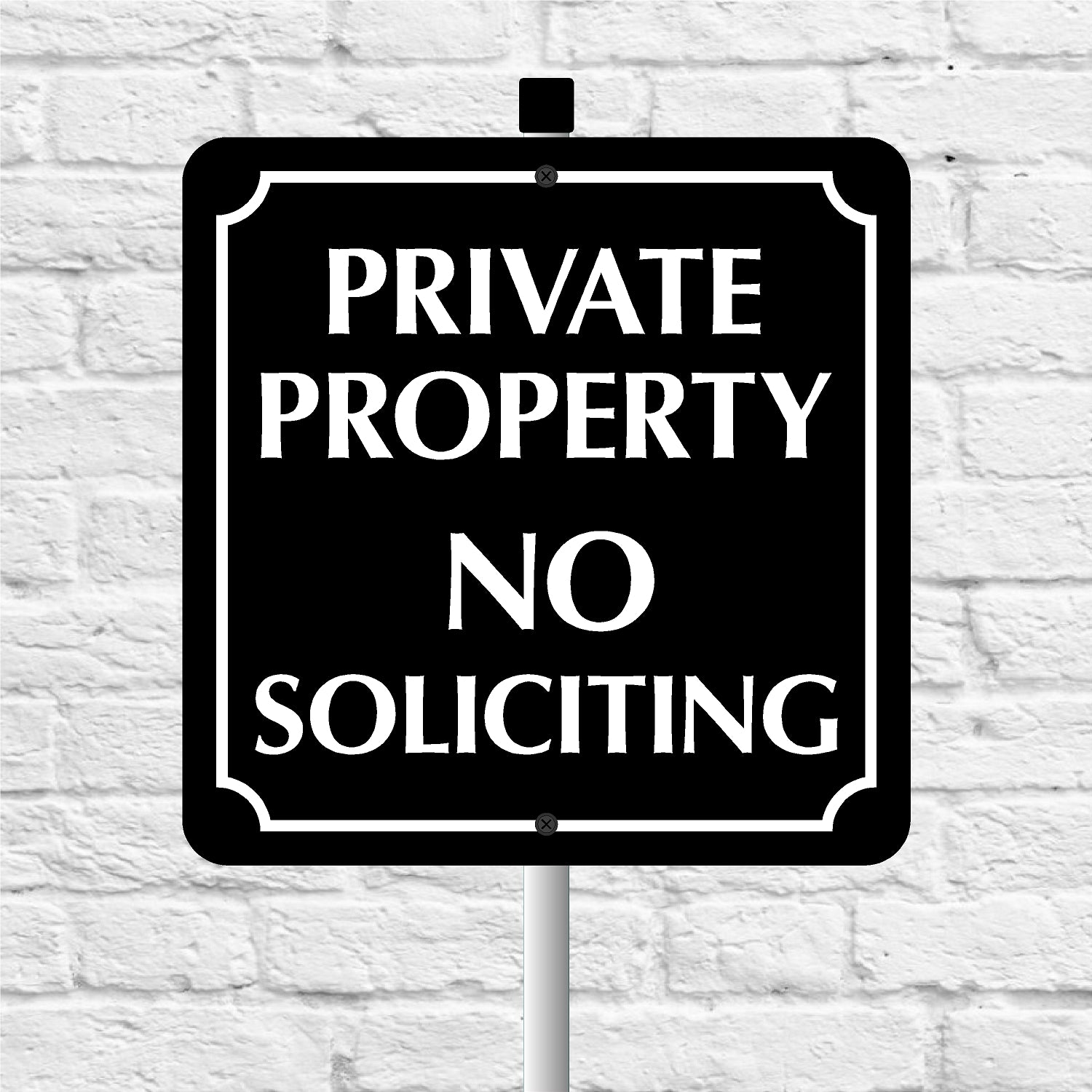 Black and white 'Private Property No Soliciting' sign against a light gray brick wall.