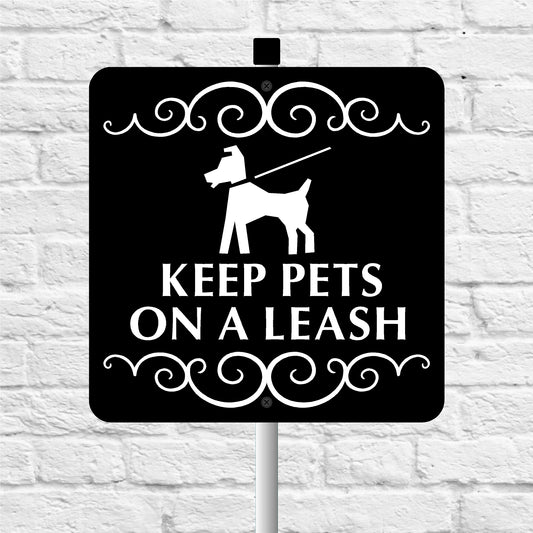 Sign with a dog silhouette and text 'Keep Pets on a Leash' against a white brick wall.
