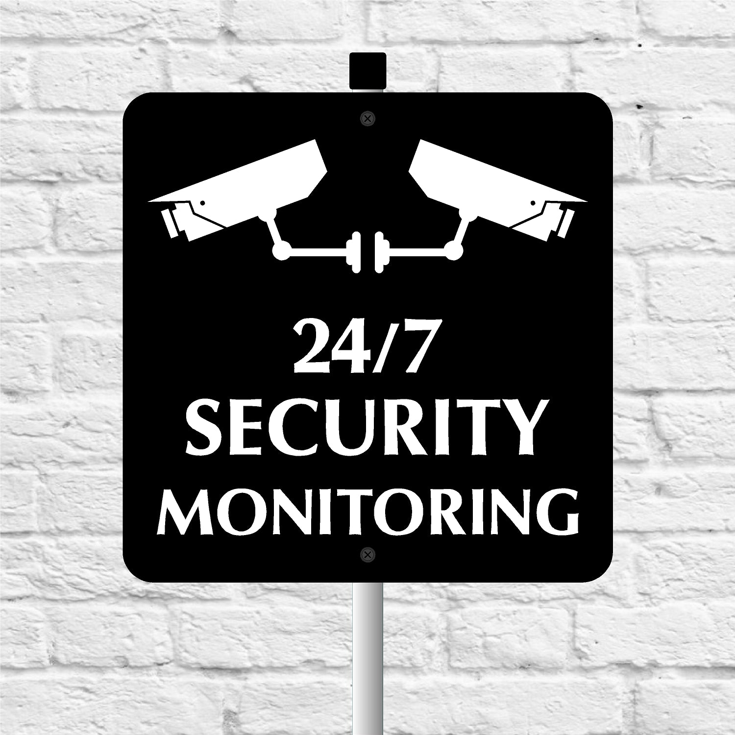 Black and white security monitoring sign with two cameras on a white brick wall background