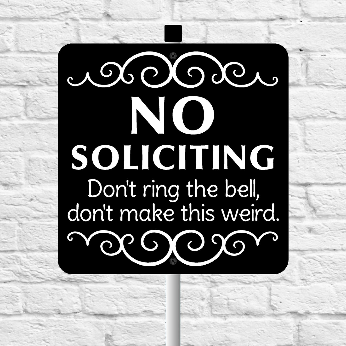 No soliciting sign with decorative elements on a white brick background