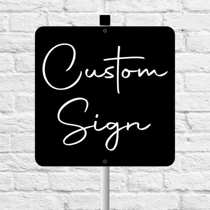 Black sign with 'Custom Sign' text on a white brick wall background