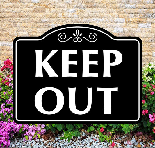 Black 'KEEP OUT' sign with decorative elements on a stone wall and floral background