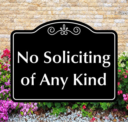 Decorative sign with 'No Soliciting of Any Kind' text in front of a stone wall and flowers.